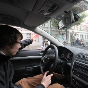 Ein Autofahrer gibt Fußgängern per Handzeichen Vorrang