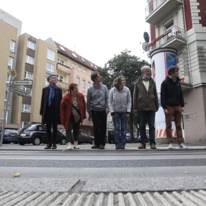 Ältere und jüngere Menschen stehen am Straßenrand