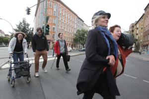 Ältere und jüngere Menschen gehen über die Straße